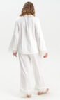 silky satin women's pajamas in ivory white with feather trim and pockets enhanced with piping, long sleeves and button up design
