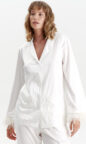 silky satin women's pjs in ivory white with feather trim and pockets enhanced with piping, long sleeves and button up design